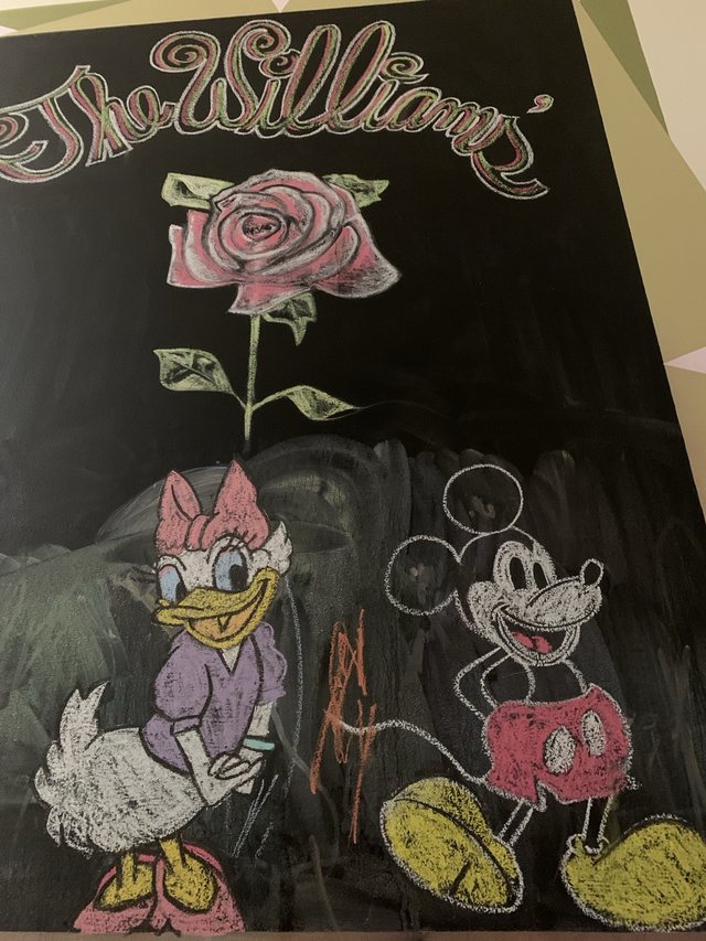 Chalkboard drawing with rose, lettering, and cartoon characters
